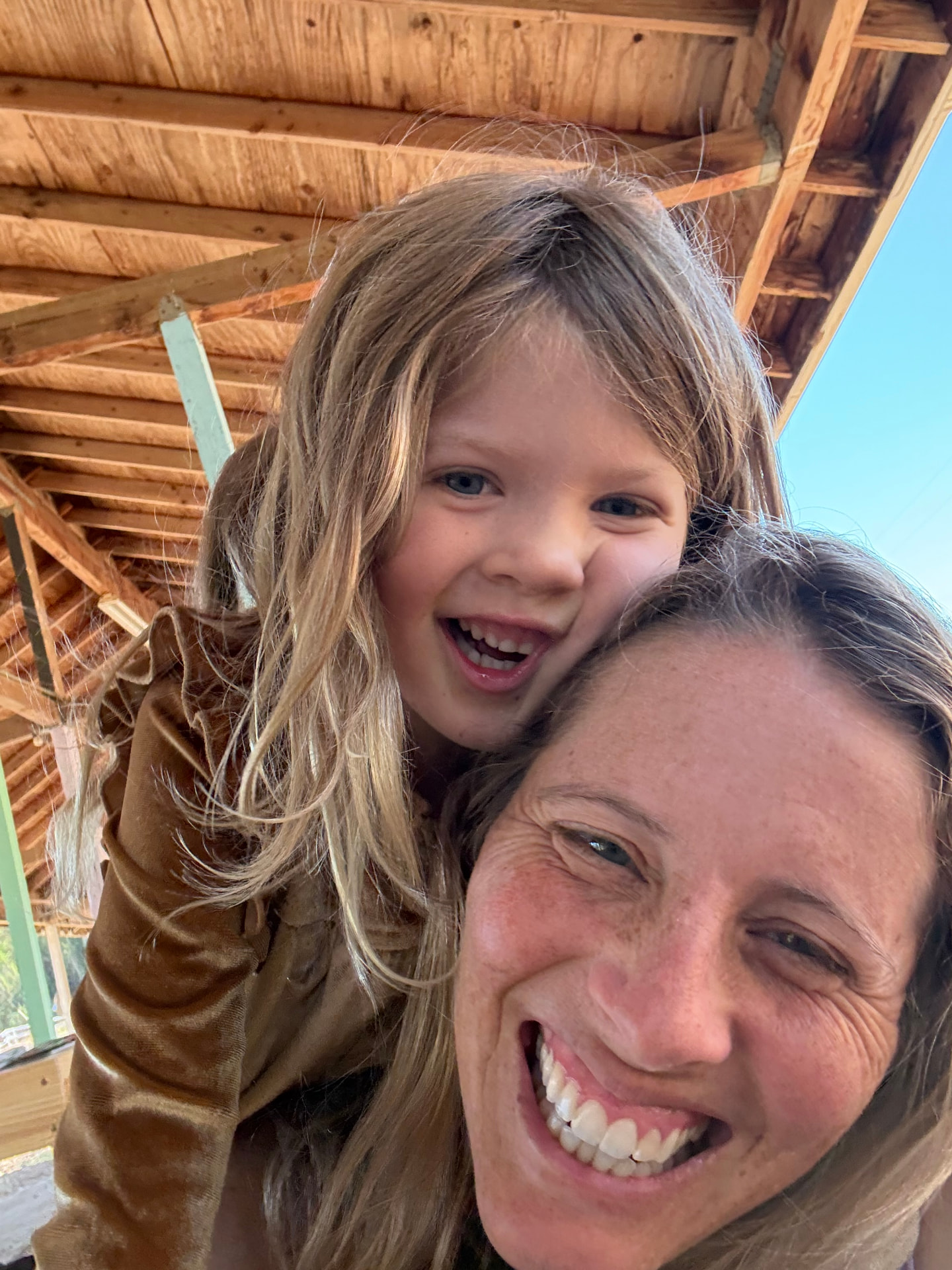 A guide and a young child laughing together inside the barn