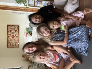 Children and guides sitting close together and smiling in a sunlit living room
